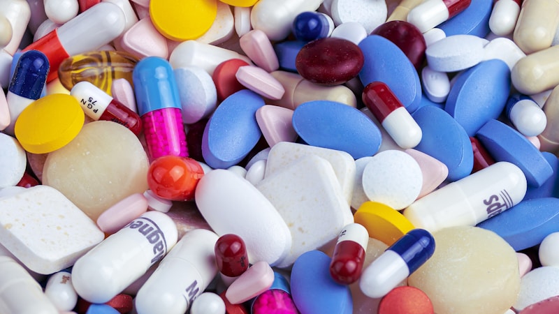 Person comparing prescription medication prices on a phone while standing in a pharmacy aisle