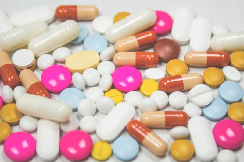 Prescription medication bottles at a pharmacy counter showing price variation between retailers