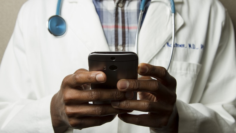 Person comparing prescription drug prices on a smartphone at a pharmacy counter