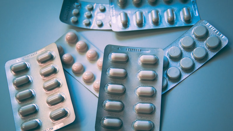 Close-up of various prescription medication bottles and pill containers on a table