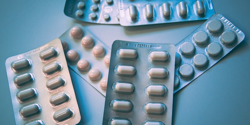 Close-up of generic and brand name prescription pills side by side on a white surface
