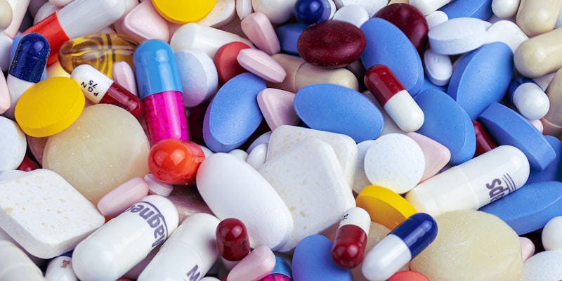 Person reviewing medication costs and comparing prescription savings options on paper
